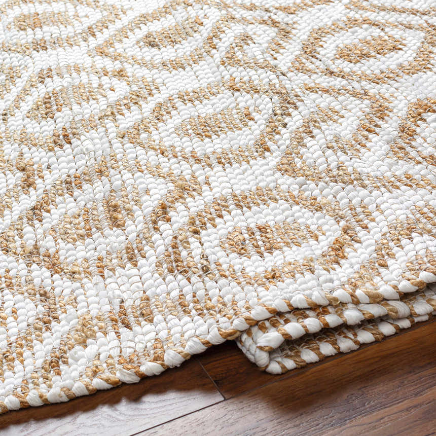 Close-up of the hand woven Isaye Beige Area Rug, featuring a geometric pattern in beige and white jute and recycled fabric. Fold