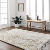 Bright living room with Ishan Cream Area Rug, wood floors, bench with books, and potted plant. Roomscene-Rectangle
