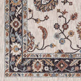 Close-up of the Adjoa Area Rug showing floral and vine pattern in black, brown, blue, and cream. Farmhouse style. Swatch