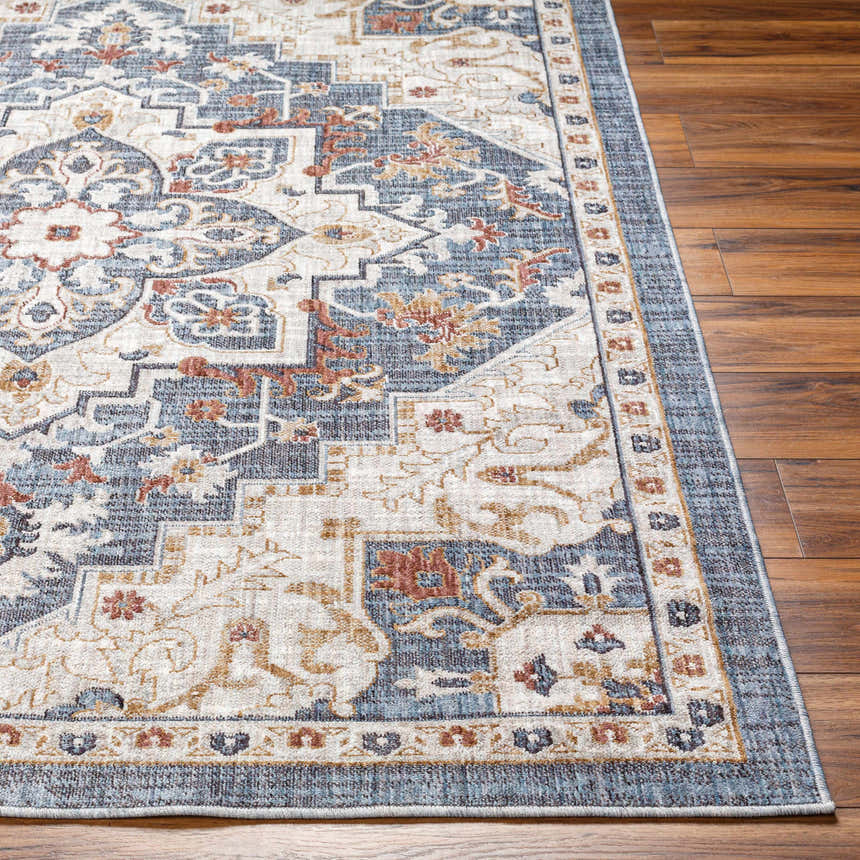 Close-up of the Lewa Blue Area Rug showing its traditional floral pattern in shades of blue, beige, and rust on a wood floor. Front