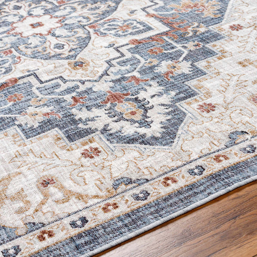 Close-up of the Lewa Blue Area Rug showcasing its traditional, ornate pattern and colors: blue, charcoal, clay, and light gray. Texture
