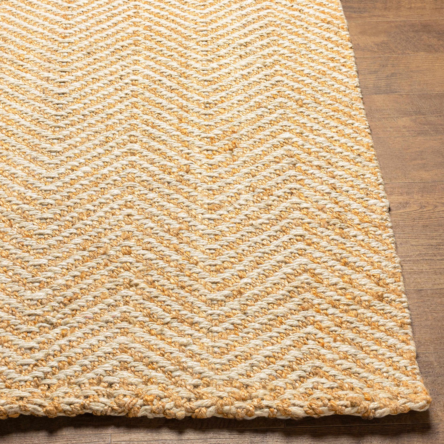 Close-up of textured Aren Area Rug. Cinnamon and light beige jute rug with a geometric chevron pattern. Front