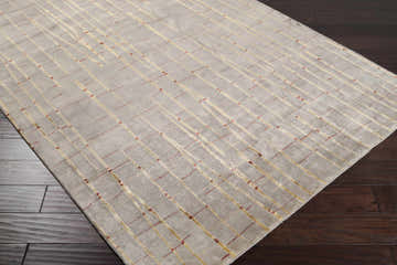 Close-up of the Slatington Area Carpet showing a gray wool rug with a gold and red geometric line pattern. Corner