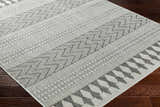 Close-up of the Asif Gray Area Rug showing the farmhouse style geometric pattern and woven texture on dark wood floors. Corner