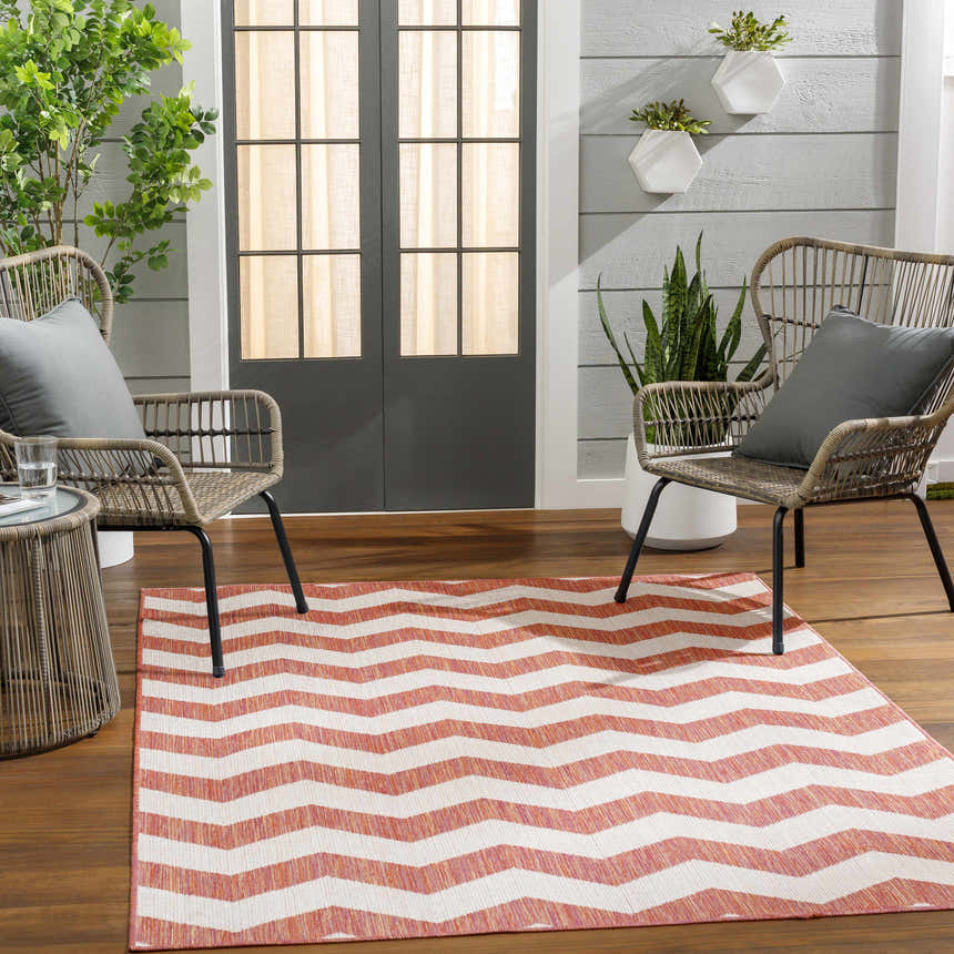 Outdoor patio scene with wicker chairs and a coral chevron Cheri Lambswool Area Carpet Area Rug. Roomscene-Rectangle