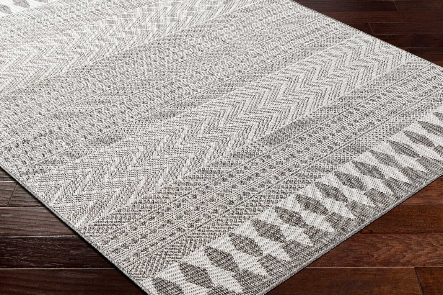 Close-up of Lali Light Gray Area Rug showing charcoal, gray, and off-white geometric patterns and textures. Corner