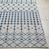 Close-up of the Lali Blue & Gray Area Rug, featuring a geometric diamond and dot pattern in denim blue on a light gray background. Front