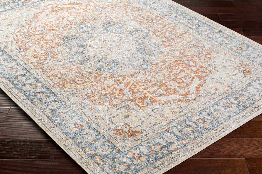 Close-up of the Emke Rust Washable Area Rug showing its faded driftwood, nutmeg, and dark beige traditional pattern. Corner