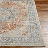 Close-up of the Emke Rust Washable Area Rug showing its traditional faded driftwood, nutmeg, and dark beige pattern and texture. Front