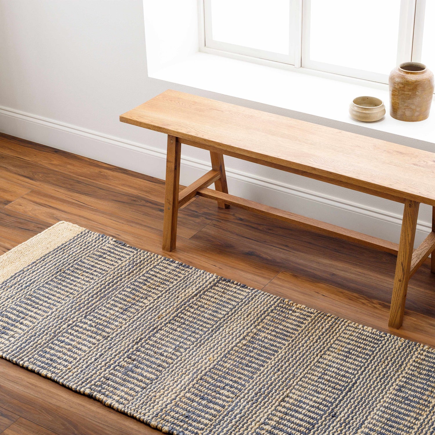 Entryway with Blue Elle Area Rug runner, wood bench, and brown wood floors. Jute rug has a geometric pattern. Roomscene-Runner