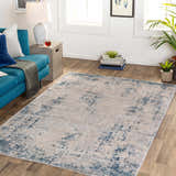 Living room scene with a blue sofa and the Saltair Textured Luxe Rug in blue and beige on wood floors. Roomscene-Rectangle