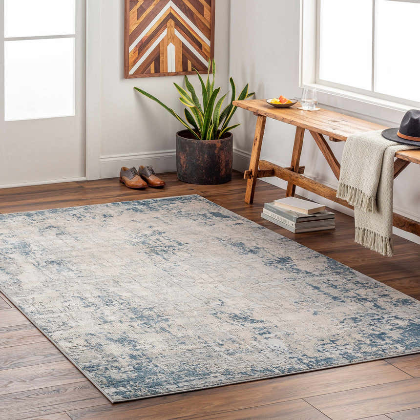 Entryway scene with a blue Saltair Textured Luxe Rug, wooden bench, plant, and shoes on dark wood floors. Roomscene-Rectangle