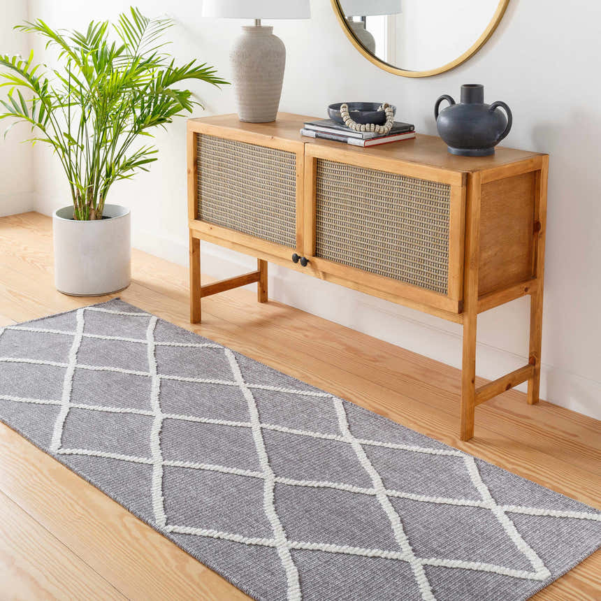 Entryway scene with Amani Gray Washable Rug runner, wood console table, lamp, round mirror, and potted plant. Roomscene-Runner