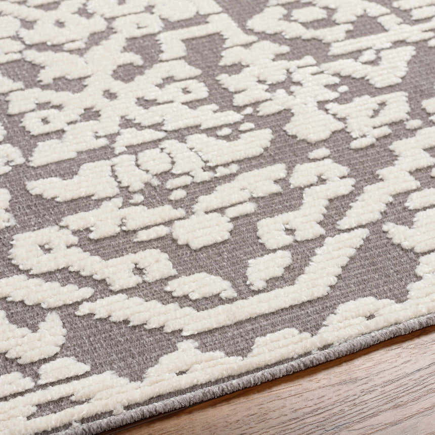 Close-up of the Beren Gray Washable Area Rug, featuring a bone and gray traditional pattern with a soft, textured feel. Texture