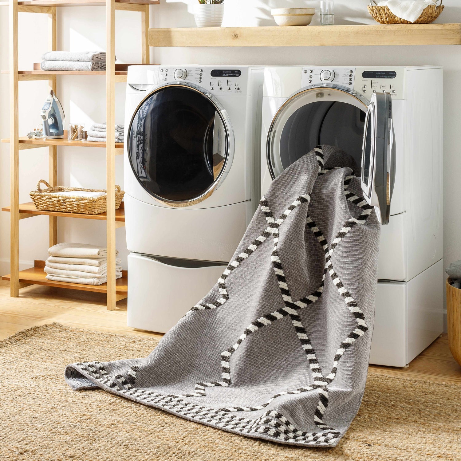 Laundry room scene with gray Rolf Textured Washable Rug coming out of the washing machine. Jute rug underneath. Washing-Machine