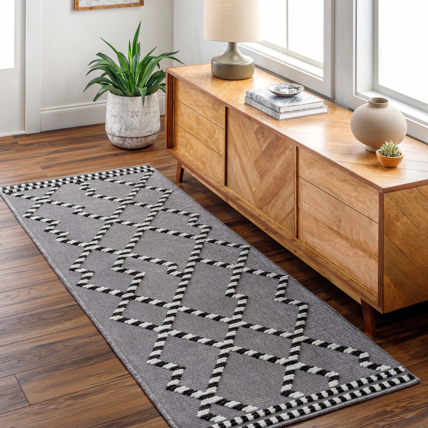 Entryway with Rolf Textured Washable Rug runner in gray with black and white geometric pattern. Wood floors and console table. Roomscene-Runner