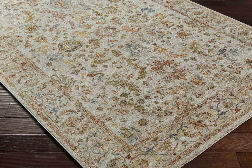 Close-up of the Asabi Tan Textured Rug. Features brick red, burgundy, blue, sage, and mustard floral pattern. Corner