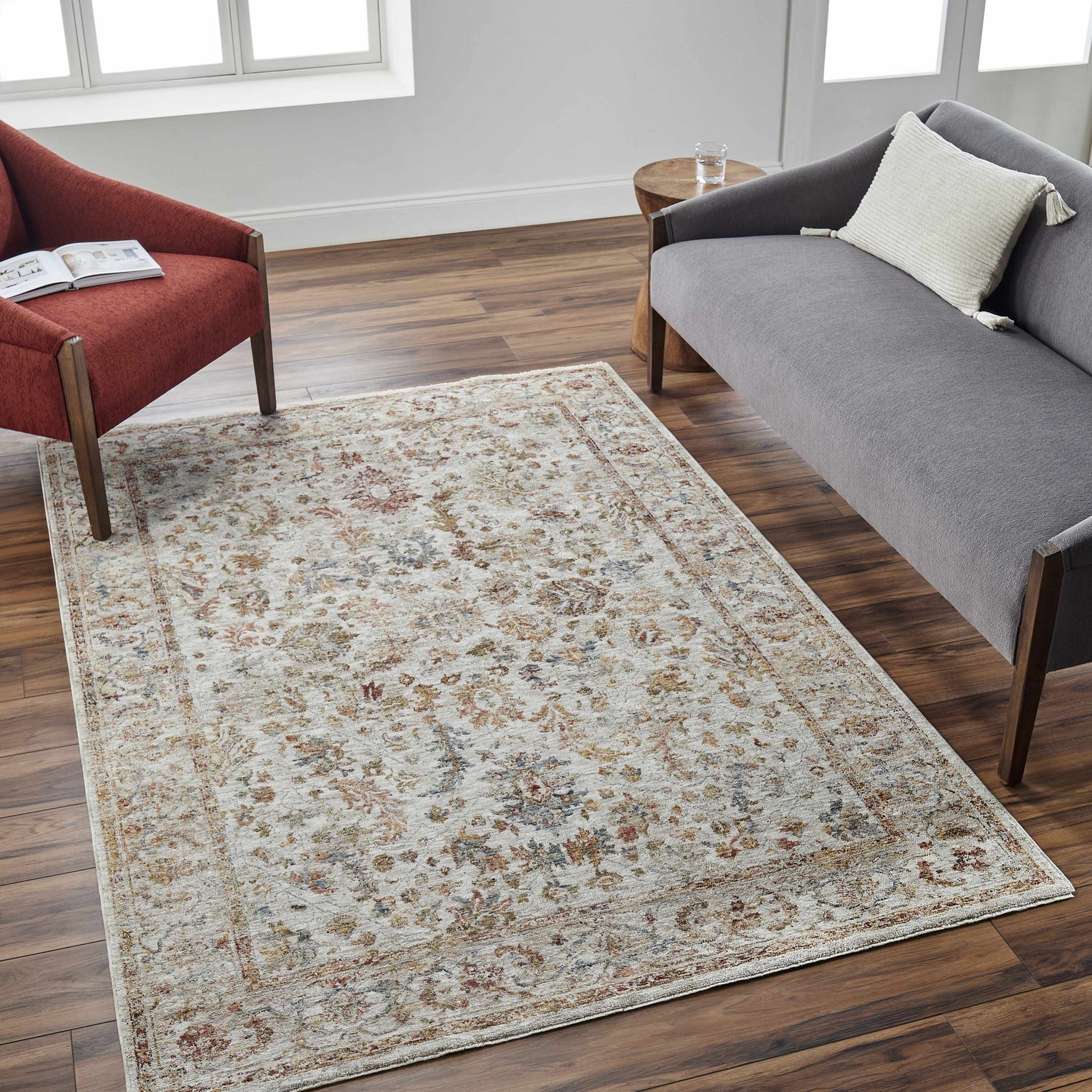 Living room scene with a tan Asabi textured rug, gray sofa, and brick red chair on a dark wood floor. Roomscene-Rectangle