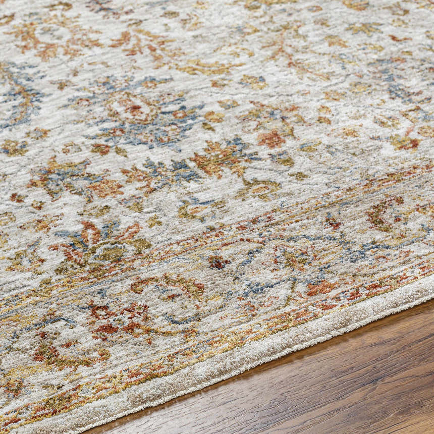 Close-up of the Asabi Tan Textured Rug showing its brick red, navy, and mustard floral pattern and soft, textured weave. Texture