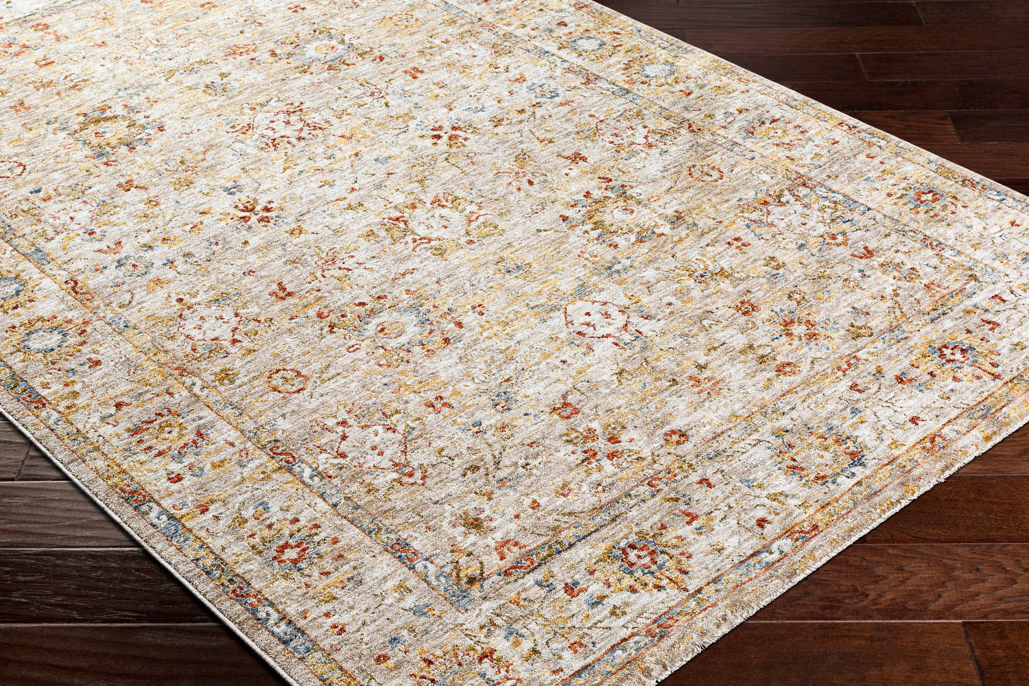 Close-up of the Duong Beige Textured Rug with Fringes, featuring a traditional floral pattern in brick red, mustard, and blue. Corner