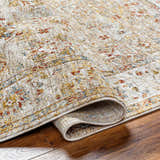 Close-up of the Duong Beige Textured Rug showing its traditional pattern, brick red, mustard, and blue colors. Fold