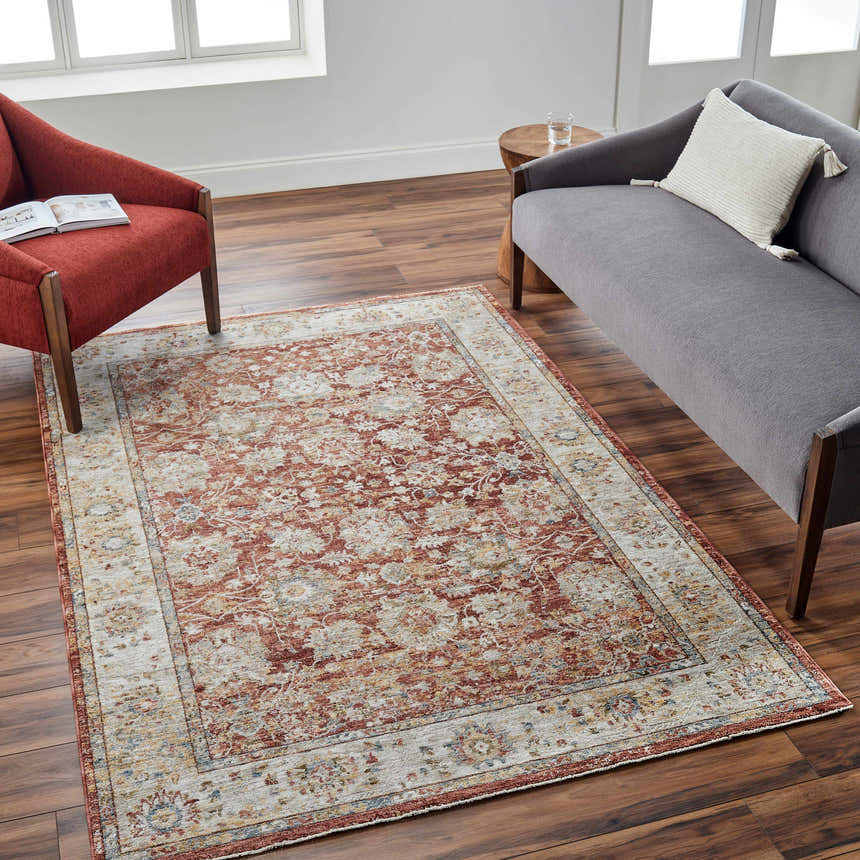 Living room scene with a Duong Rust Textured Rug, gray sofa, and red chair on a wood floor. Roomscene-Rectangle