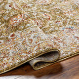 Close-up of the Dyan Green Textured Rug showing its farmhouse style, olive, sage, and tan colors, and machine-woven construction. Fold