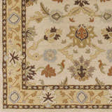Close up of the hand-tufted Smoot Area Rug. Beige wool rug with traditional floral and leaf pattern in brown, tan, and slate blue. Swatch