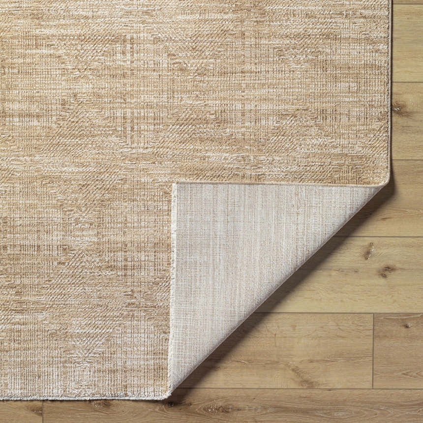 Close-up of the Dekan Tan Area Rug showing its lambswool and light brown colors and machine woven construction. Fold