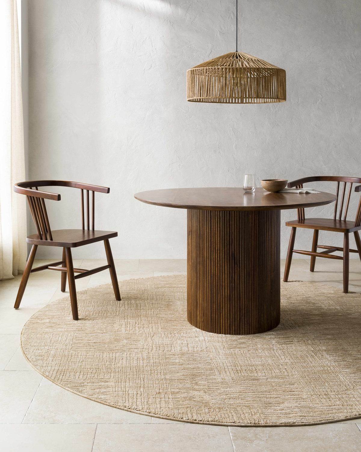 Dining room scene with a round wood table on a beige, textured round Goren Beige Area Rug. Roomscene-Round