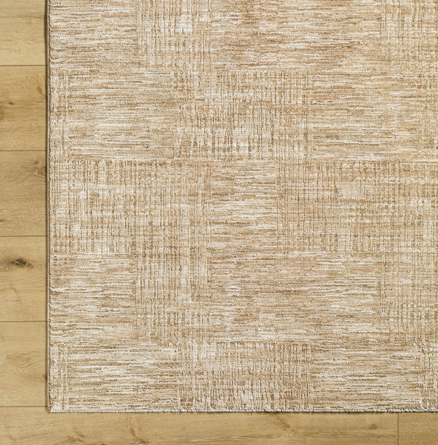 Close-up of the beige Goren Area Rug showing its contemporary pattern and soft texture on wood floors. Corner