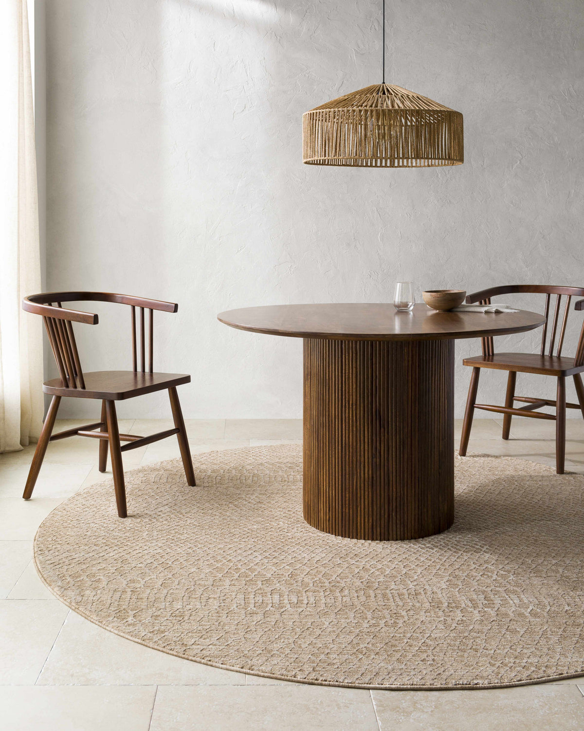 Dining room scene with round wood table and chairs on a tan round Kamin Area Rug. Roomscene-Round