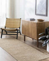 Living room scene with a tan Katia rug, woven chair, and wood cabinet, creating a minimalist, farmhouse style. Roomscene-Runner