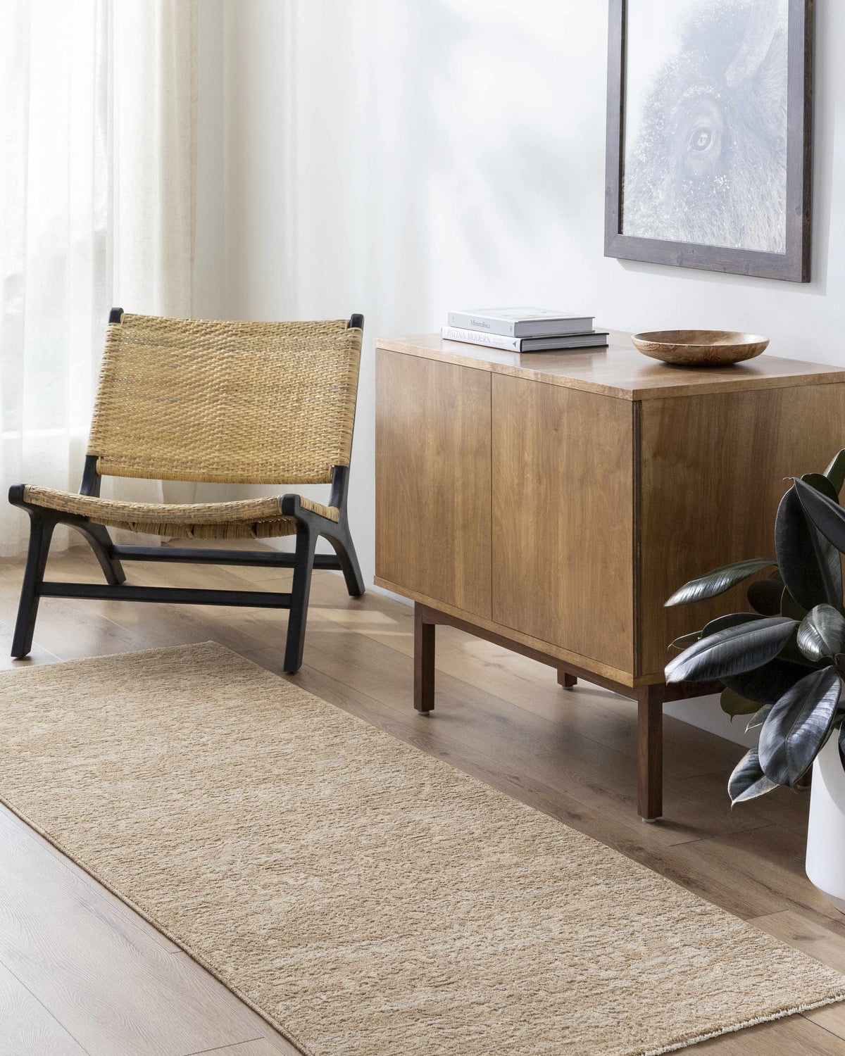 Living room scene with a tan Katia rug, woven chair, and wood cabinet, creating a minimalist, farmhouse style. Roomscene-Runner
