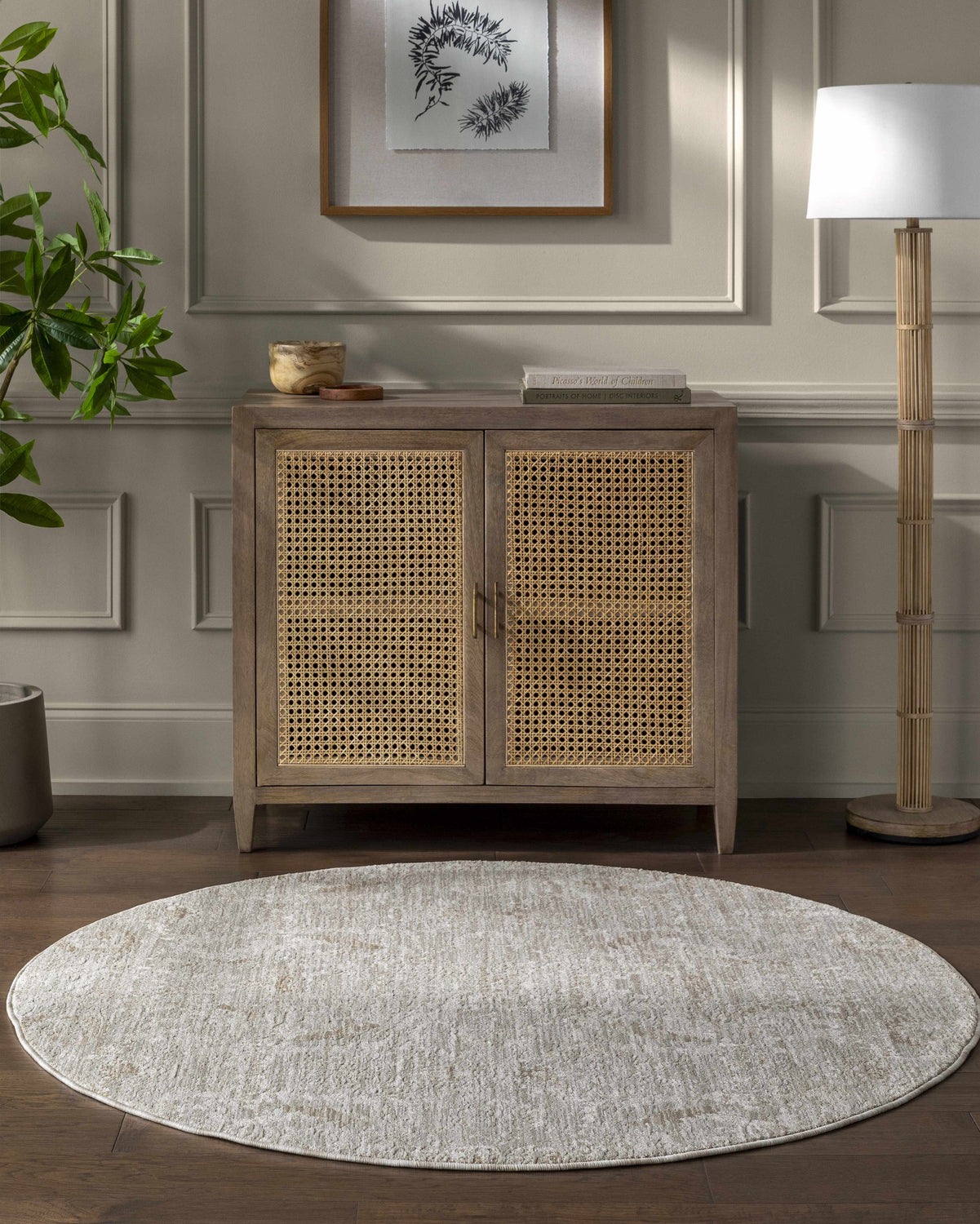 Living room scene with light gray Katia area rug, wood cabinet, and floor lamp. Roomscene-Round