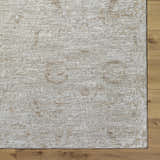 Close-up of the light gray and natural gray Katia Area Rug showing its subtle traditional pattern and soft texture. Corner