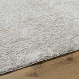 Close-up of the light gray Katia Area Rug showing its subtle traditional pattern and soft, textured weave on wood floor. Texture