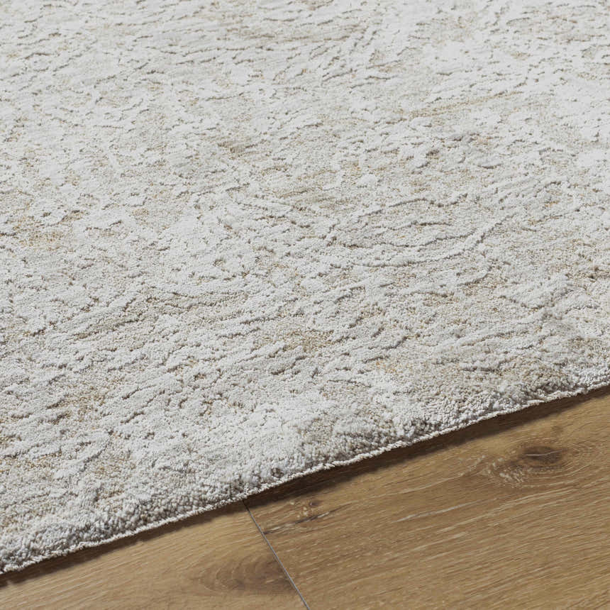 Close-up of the light gray Katia Area Rug showing its subtle traditional pattern and soft, textured weave on wood floor. Texture