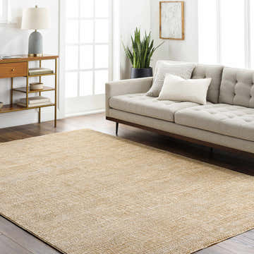 Living room with a tan Kegan Area Rug, beige sofa, wood console table, and indoor plant. Roomscene-Rectangle