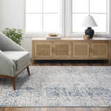 Living room scene with a gray armchair and the light gray Kamea Area Rug. Roomscene-Rectangle