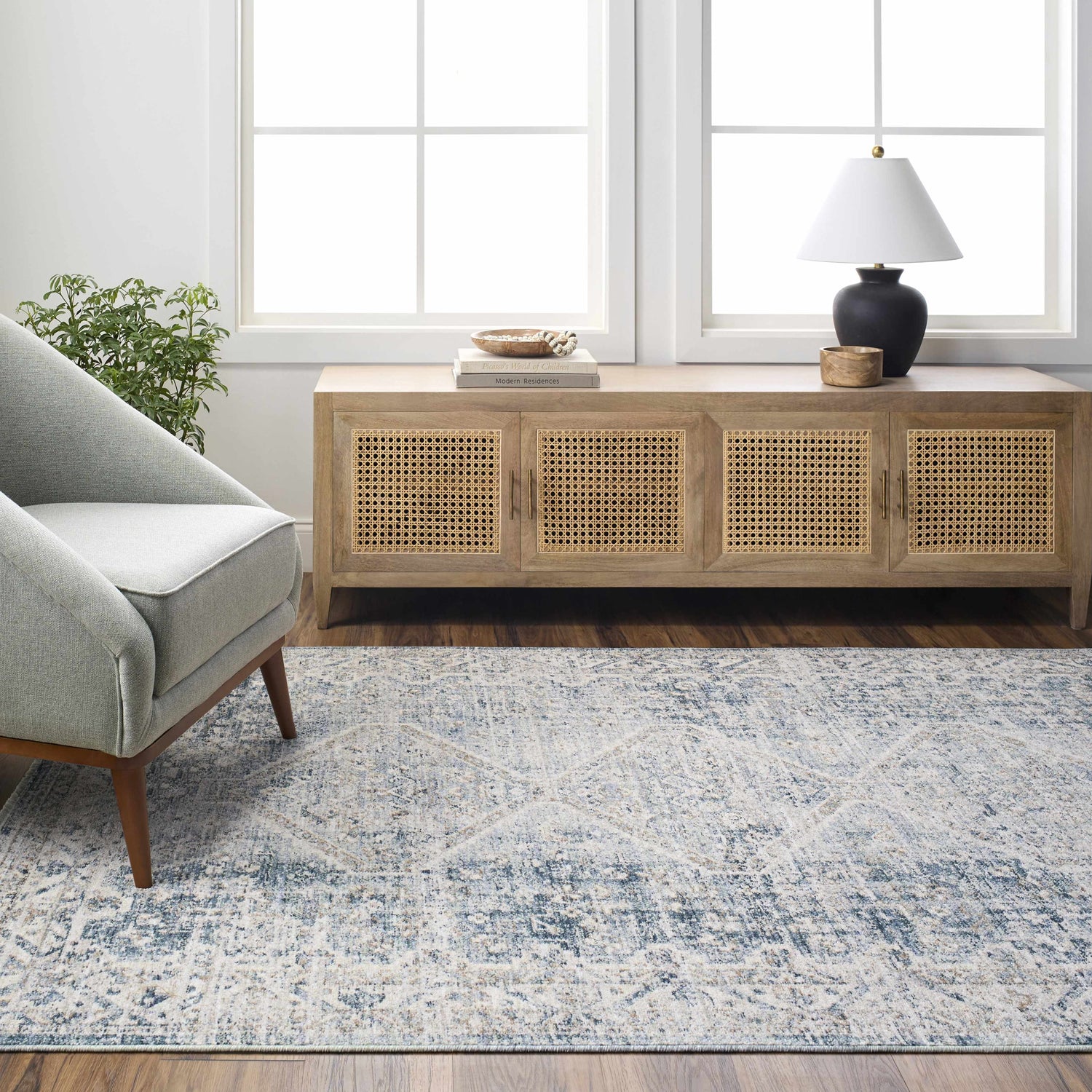 Living room scene with a gray armchair and the light gray Kamea Area Rug. Roomscene-Rectangle