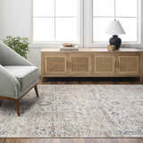 Living room scene with a beige Keran Area Rug, gray chair, wood cabinet, and natural light. Roomscene-Rectangle