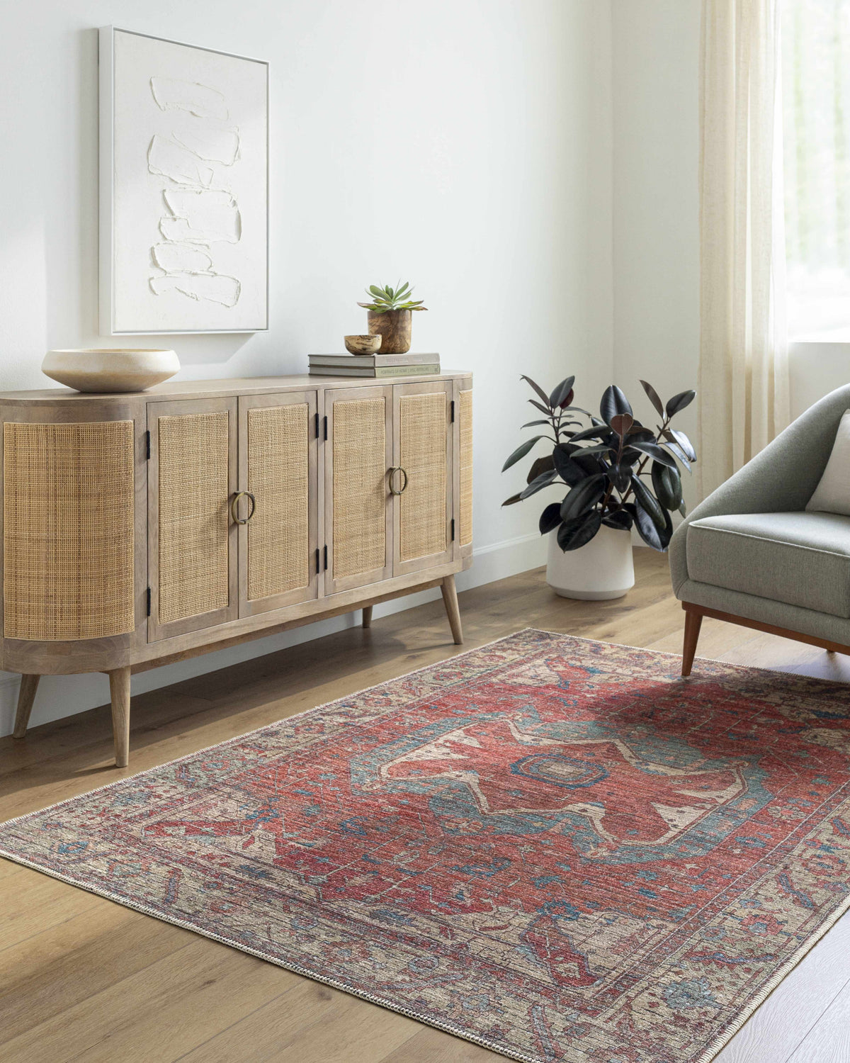 Living room scene with a terracotta and blue Saif Area Rug, wood cabinet, and gray chair. Roomscene-Rectangle