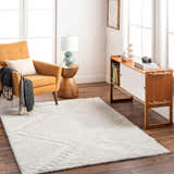 Living room scene with the Edsel Off-White Area Rug, mustard chair, wood cabinet, and hardwood floors. Bright, airy, and modern. Roomscene-Rectangle
