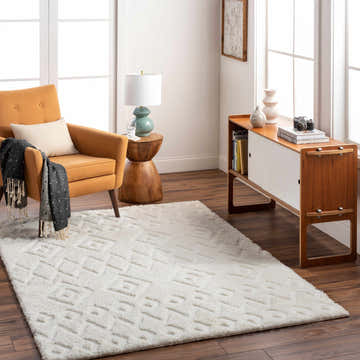 Living room scene with a beige Hoshi Area Rug, orange chair, and mid-century modern cabinet. Roomscene-Rectangle