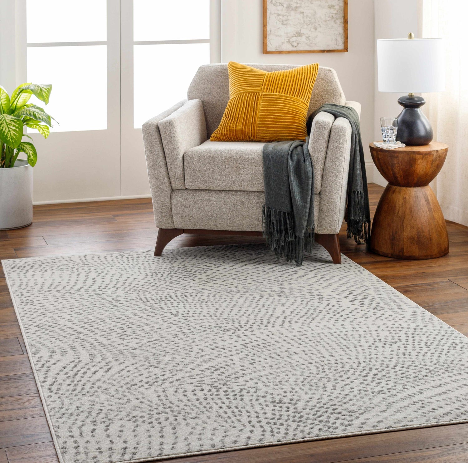 Living room scene with a light gray Sina Area Rug, armchair, and wood side table. Roomscene-Rectangle