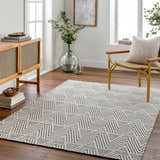 Living room with a Dawid Wool Area Rug, wood cabinet, chair, and geometric black and off-white pattern. Roomscene-Rectangle