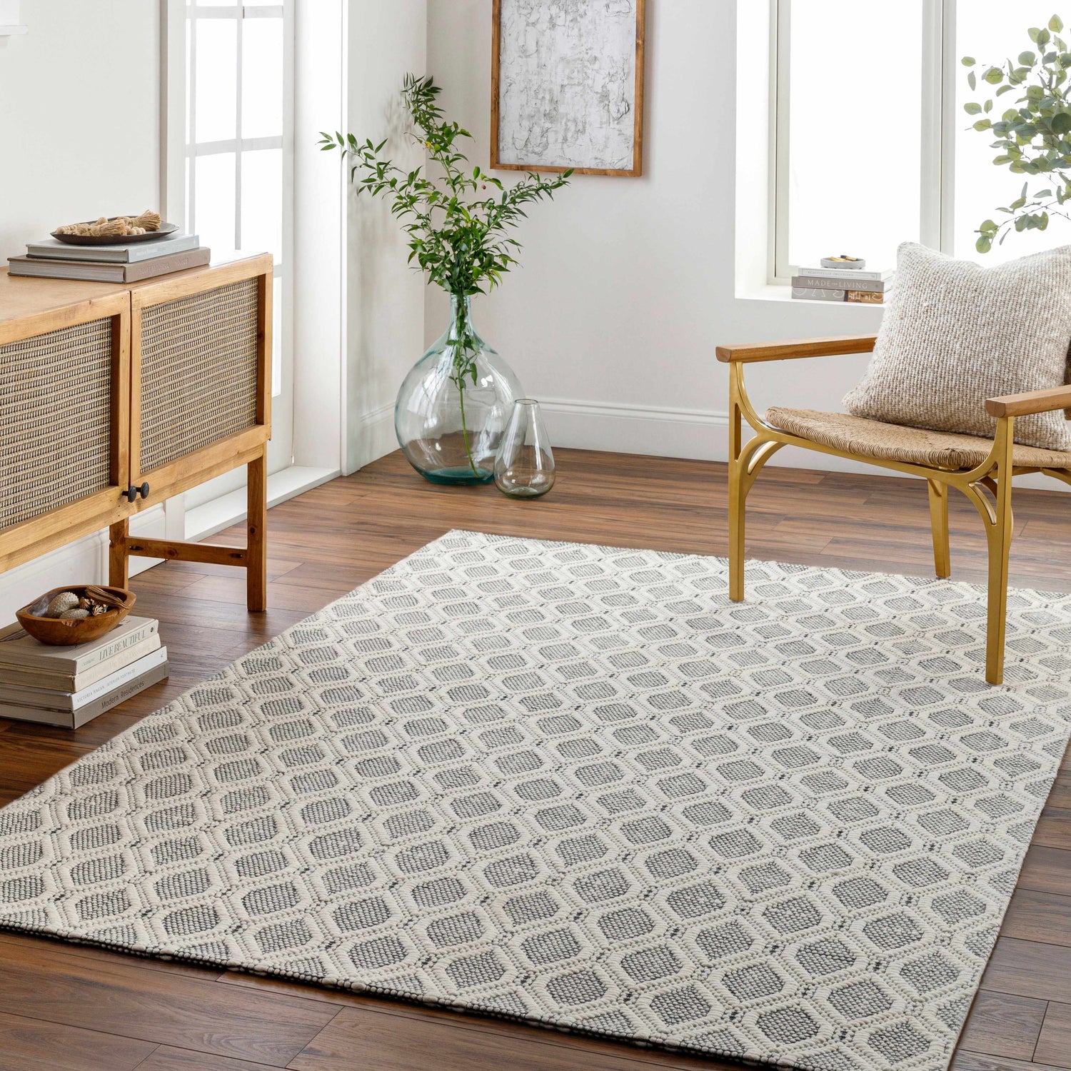 Living room scene with a geometric Edyta Area Rug in bone and gray, wood cabinet, and gold chair. Roomscene-Rectangle