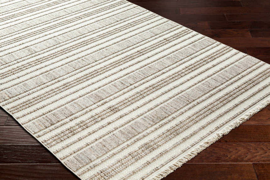Close-up of the Avari Area Rug showing a striped pattern in beige and brown on dark wood floors. Corner
