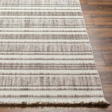 Close-up of Avari Area Rug showing beige and brown stripes, woven texture, and fringe detail on a wood floor. Front